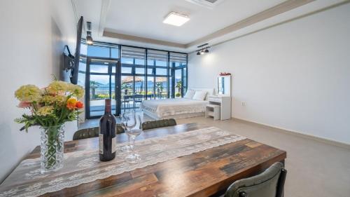 a dining room with a table with a vase of flowers at Yeosu Wayo Ocean View Pension in Yeosu