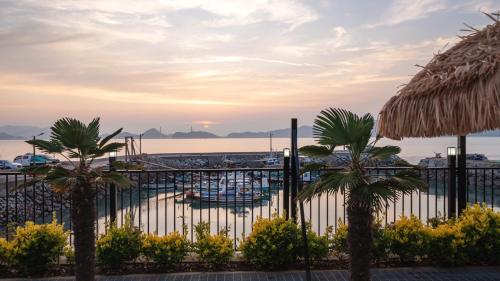 a fence with palm trees in front of a marina at Yeosu Wayo Ocean View Pension in Yeosu