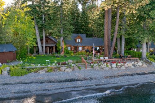 a house in the woods with a yard at Homewood Lakefront by AvantStay Private Beach Lake Access Views in Homewood