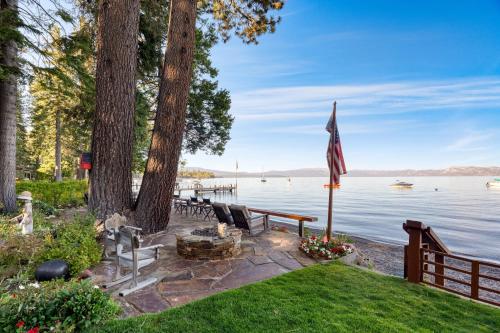 a fire pit on the shore of a lake at Homewood Lakefront by AvantStay Private Beach Lake Access Views in Homewood