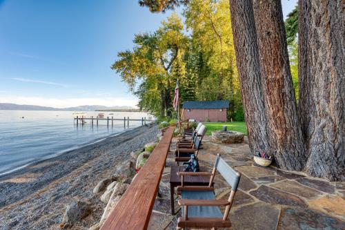 a row of benches on the shore of a lake at Homewood Lakefront by AvantStay Private Beach Lake Access Views in Homewood