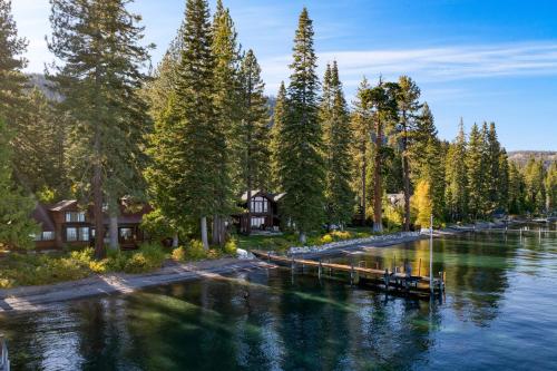 a river with houses and trees and a dock at Homewood Lakefront by AvantStay Private Beach Lake Access Views in Homewood