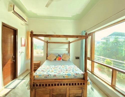 a bedroom with a bed in a room with a window at House Of Vedas in Greater Noida