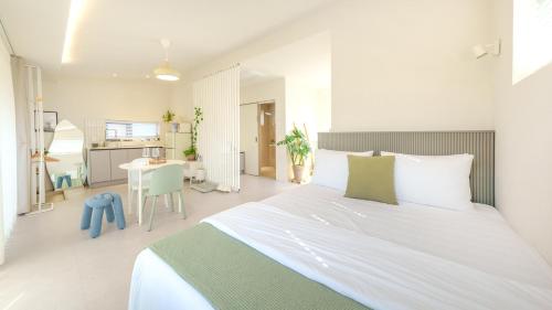 a bedroom with a large white bed and a table at gyeongju daol dokchae pension in Gyeongju