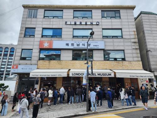 a crowd of people standing outside of a building at Gyedong byeolchae, Bukchon hanok village & Namsan tower city view Warm morning sunshine Tranquil Rest in Seoul