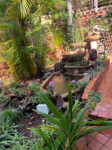 a garden with a pond with flowers and plants at At Rosies on Robin - Luxury & Comfort in Rustenburg