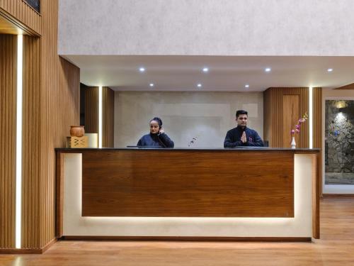 two people standing behind a counter in a hotel lobby at Regenta Place Dalhousie at Mall Road in Dalhousie