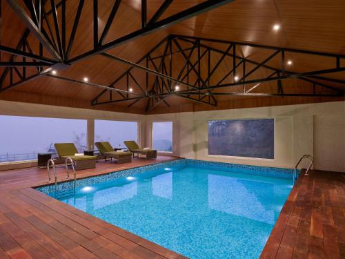 a swimming pool in a building with a large at Regenta Place Dalhousie at Mall Road in Dalhousie