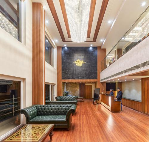 a lobby with green leather couches and a courtroom at Regenta Place Dalhousie at Mall Road in Dalhousie