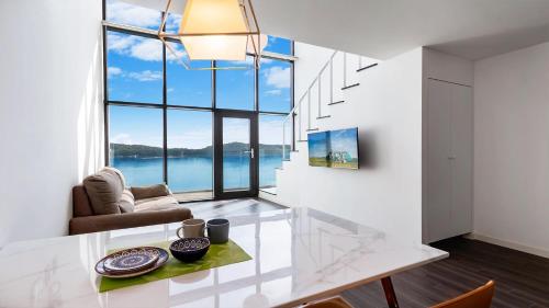 a living room with a glass table and a large window at Tongyeong FH365 Pension in Tongyeong