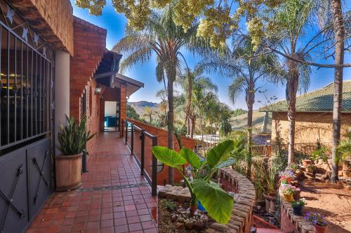 a brick walkway leading to a house with palm trees at At Rosies on Robin - Luxury & Comfort in Rustenburg