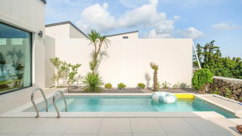 a swimming pool in the backyard of a house at Jeju stay eden Dokche poolvila Pension in Seogwipo