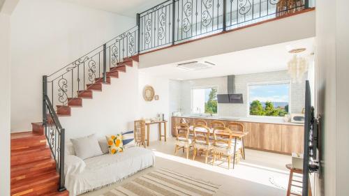 a living room with a staircase and a kitchen with a table at Jeju stay eden Dokche poolvila Pension in Seogwipo