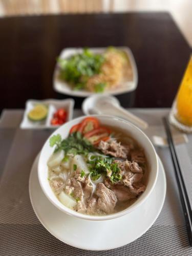 una ciotola di zuppa su un tavolo con un piatto di cibo di Hizo Garden Resort a Buôn Du Enguôl
