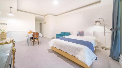 a white bedroom with a bed and a table at yangpyeong beulleosseom pet spa pension in Yangpyeong
