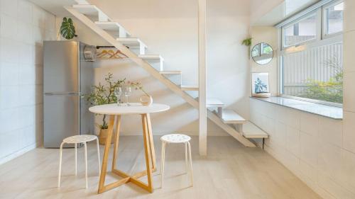 a small table and stools in a room with a staircase at gyeongju planb pet pension in Gyeongju