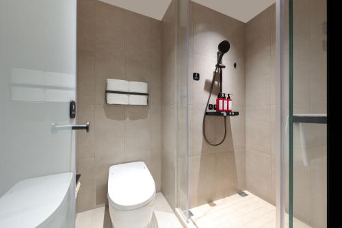 a bathroom with a toilet and a shower at Atour Light Hotel Xishuangbanna Jinghong Gaozhuang in Jinghong