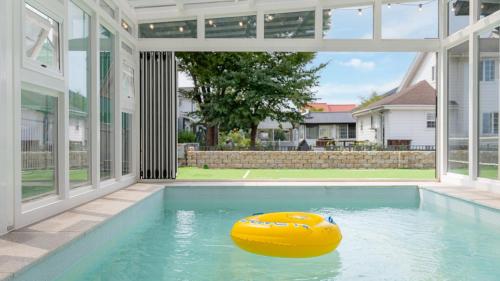 a large swimming pool with a yellow rubber boat in it at daebudo uramstay pension in Ansan