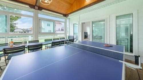 a ping pong table in a room with windows at daebudo uramstay pension in Ansan