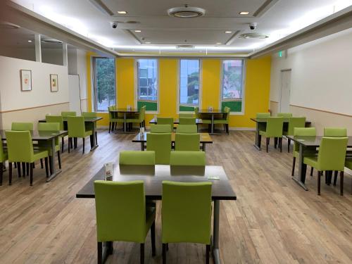 a classroom with tables and chairs and yellow walls at ANA Holiday Inn Sapporo Susukino by IHG in Sapporo