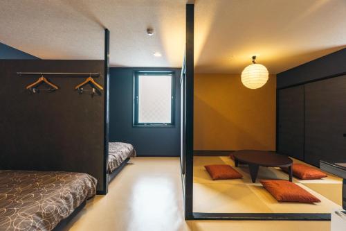 a bedroom with a bed and a table and a mirror at KINGYO - Doyanen Hotels in Osaka