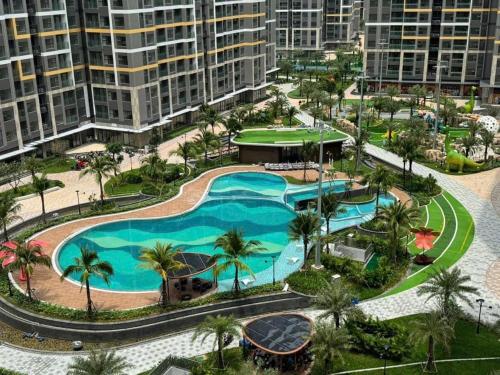 an aerial view of a pool with palm trees and buildings at Bống Homestay-Luxury Apartment in Gò Công
