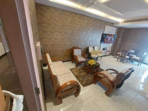 a living room with a couch and a table and chairs at Hotel Yathin in Mysore