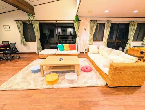 a living room with a couch and a table at レインボーヒルズ 熱海 #ダーツ #卓球 #サウナ #バーベキュー in Atami