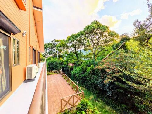 a balcony with a wooden walkway next to a building at レインボーヒルズ 熱海 #ダーツ #卓球 #サウナ #バーベキュー in Atami