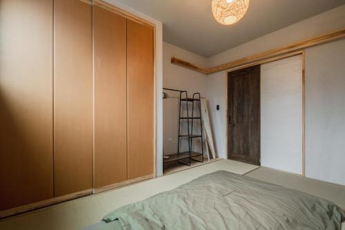 a bedroom with a bed and a closet at Rita HOSTEL in Fukuihama