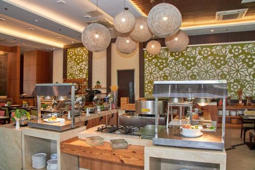 a restaurant with a counter with food on it at Harolds Hotel Cebu in Cebu City