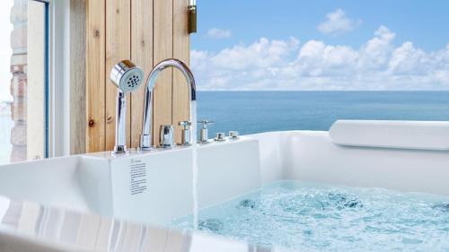 a bath tub with water coming out of it at Sokcho Moreve Pension in Sokcho