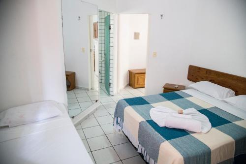 a hotel room with a bed with towels on it at Residencial Ponta Negra Flat in Natal