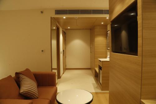 a living room with a couch and a television at Tulip Inn Zirakpur in Chandīgarh