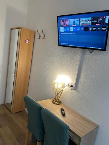a room with a table and a tv on a wall at Hotel Haus Schwan Köln in Cologne