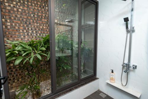 una ventana de cristal en el lateral de un edificio con plantas en Cozy Embassy Garden, en An Dương