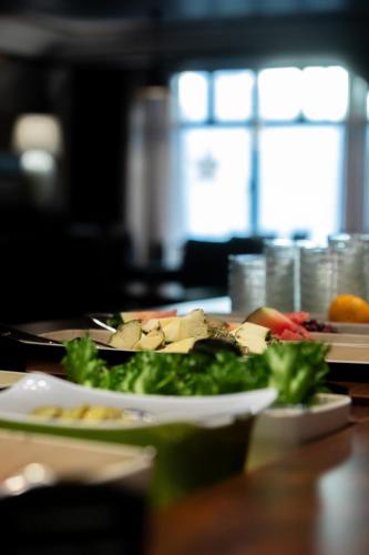 ヴァルカウスにあるHotel Oscarのテーブルの上に食べ物の皿が置かれたテーブル