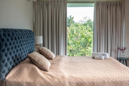 a bedroom with a bed with a blue headboard and a window at La Maroma 3 BHK Splendid Villas in Anjuna - Pvt Pool- Garden & Caretaker in Vagator