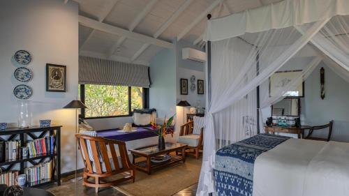 a bedroom with a bed and a table and a desk at Kahanda Kanda in Koggala