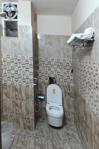 a bathroom with a white toilet in a room at Hotel Ram Janaki Palace in Tikri Kalān