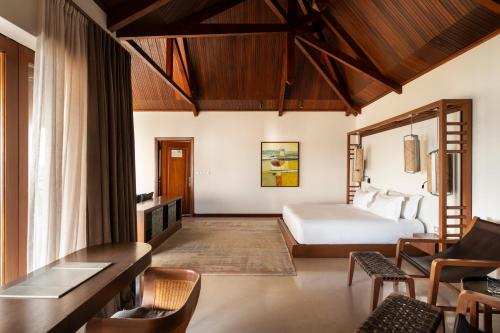 a bedroom with a bed and a table and chairs at Constance Lemuria in Grand'Anse Praslin