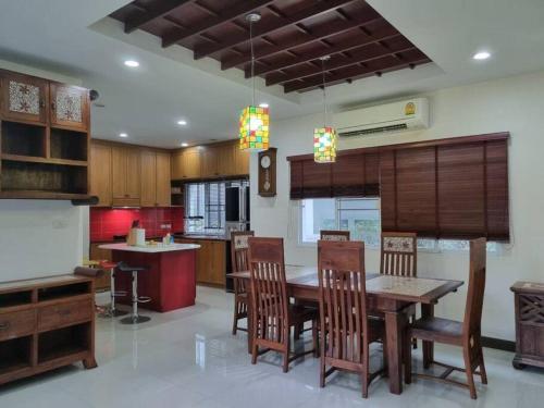 eine Küche mit Esstisch und Stühlen in der Unterkunft Modern private home in quiet gated community in Ban Hua Khao Sammuk