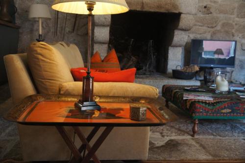 uma sala de estar com um sofá e uma mesa com um candeeiro em Casa de Sezim em Guimarães