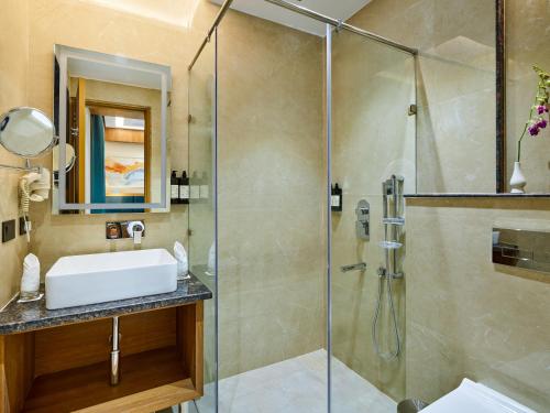 a bathroom with a sink and a shower at Regenta Place Dalhousie at Mall Road in Dalhousie