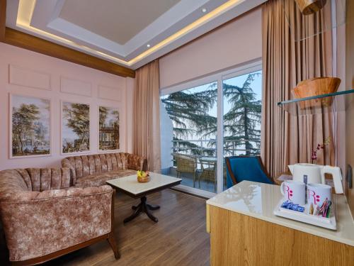 a living room with a couch and a table at Regenta Place Dalhousie at Mall Road in Dalhousie
