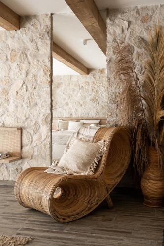 a large wooden bed in a room with a stone wall at Villa La Roca Garden and Spa in Kościelisko