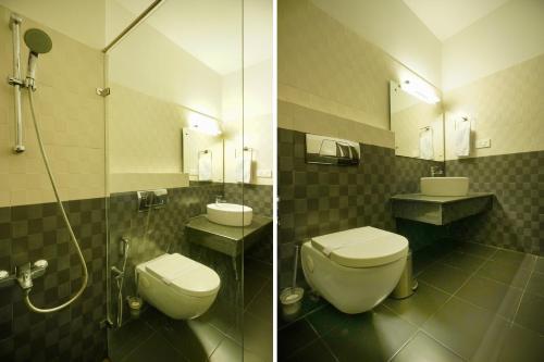 a bathroom with a toilet and a sink and a shower at Townhouse Mookkannoor Tourist Home in Cochin