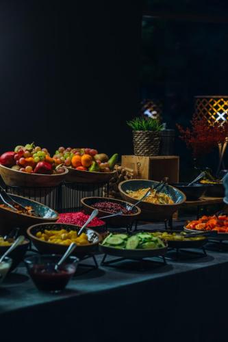 a table topped with bowls of fruits and vegetables at Gabija Hotel SPA & Conferences in Palanga