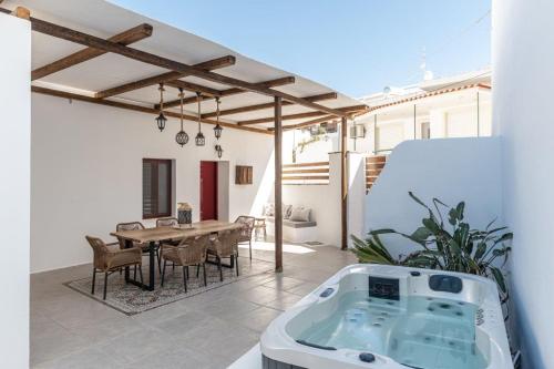 a patio with a table and a bath tub at Yria Traditional House in Vívlos