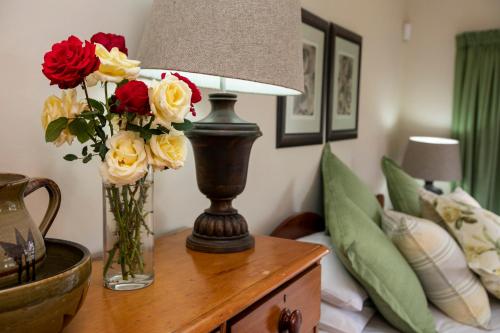 a table with a lamp and flowers on it at Chikanka in Himeville